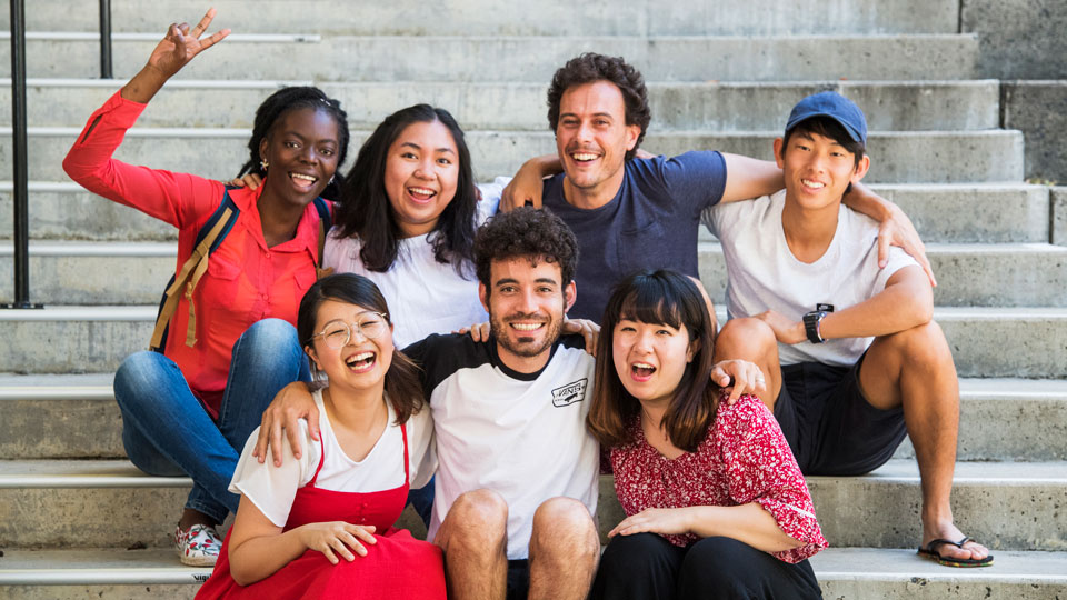 Group of international students smiling and waving