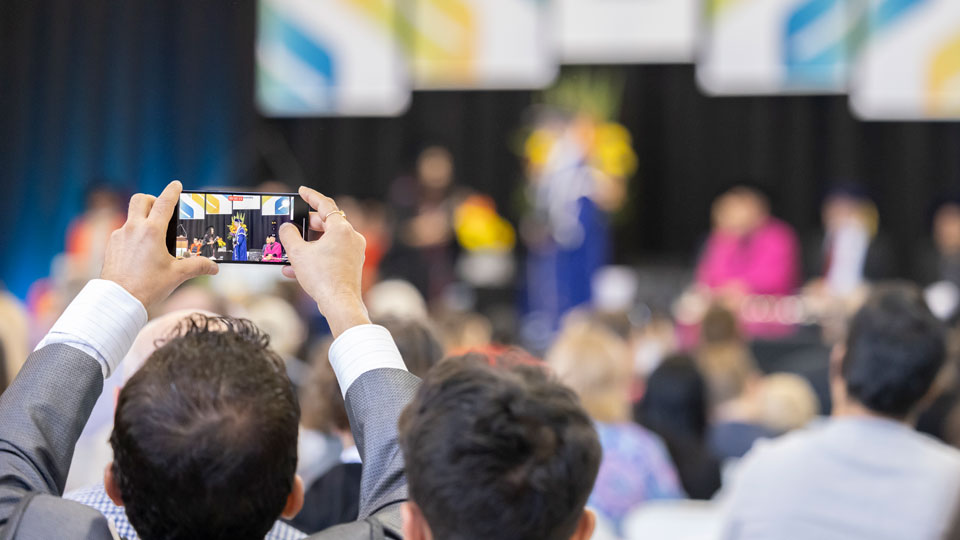 Man taking photo with phone at a Southern Cross University graduation